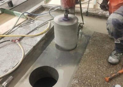 Vus Core Drilling machine performing core drilling on concrete surface.