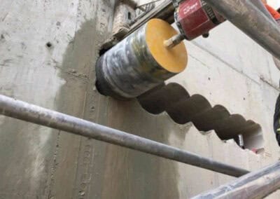 Core drilling machine in action on concrete wall for construction.