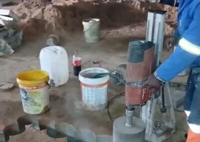 Vus Core Drilling technician operating a core drill rig to cut a stitch-drilled stairway opening in a concrete slab at Diplomat Hotel, Johannesburg CBD
