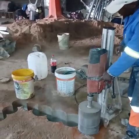 Vus Core Drilling technician operating a core drill rig to cut a stitch-drilled stairway opening in a concrete slab at Diplomat Hotel, Johannesburg CBD